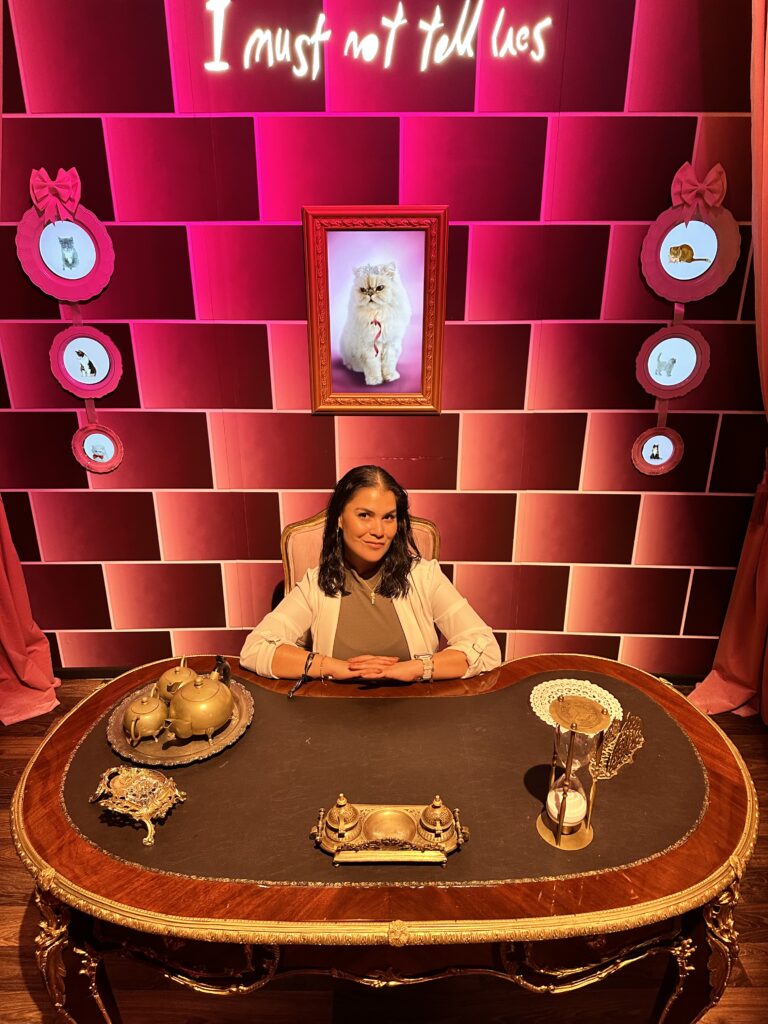 Sitting in Dolores Umbridge's desk at the NYC Harry Potter Exhibition